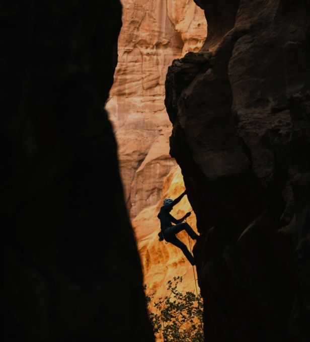 A climber in a gorge climbs up a rock.
