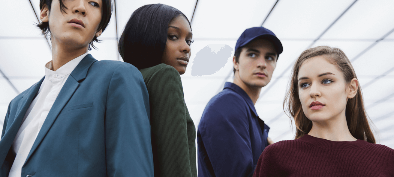 Four young people posing against a white office ceiling.